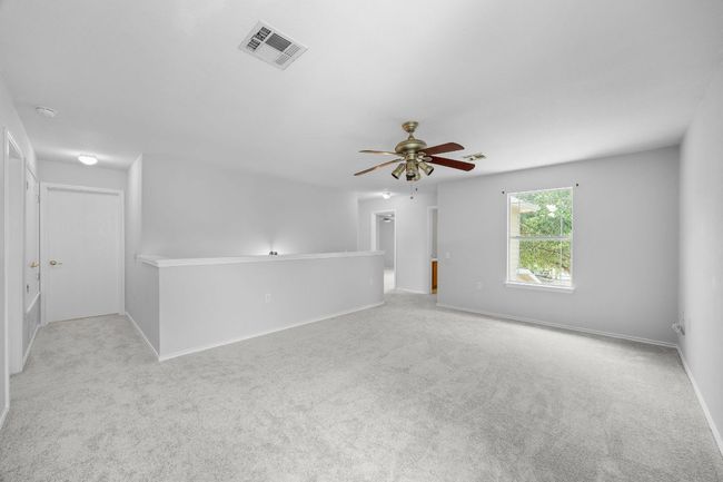 Newly carpeted bonus room features a ceiling fan and fresh paint. Plenty of space to spread out. | Image 16
