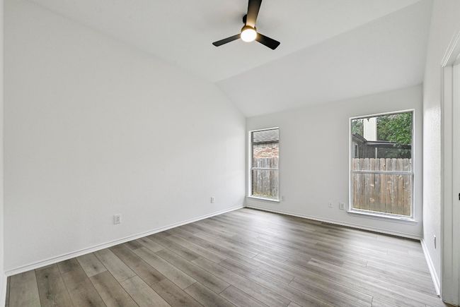 Empty room with vaulted ceiling, wood finished floors, and ceiling fan | Image 17