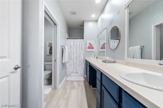 Bathroom featuring oversized vanity, double sink, and ceiling fan | Image 38