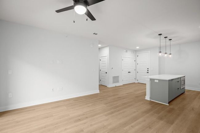 Unfurnished living room featuring a ceiling fan, light wood-style flooring, and recessed lighting | Image 10