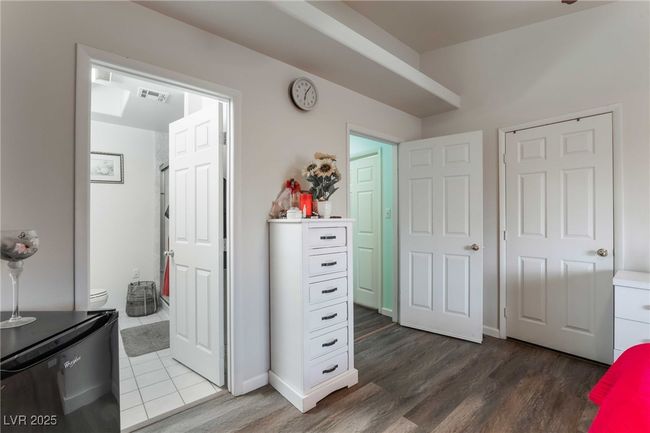Bedroom with visible vents, refrigerator, ensuite bath, and dark wood-style flooring | Image 22