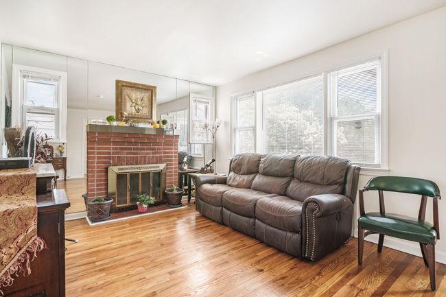 Living room with wood finished floors and a fireplace | Image 6