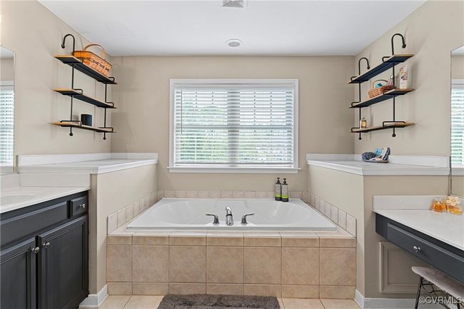 Full bathroom featuring tile patterned flooring, a bath, and vanity | Image 32