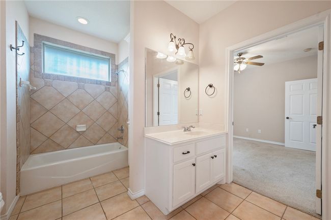 Full bath with tile patterned floors, vanity, shower / tub combination, and ceiling fan | Image 14