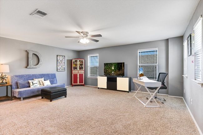 Carpeted living room with plenty of natural light, a ceiling fan, and baseboards | Image 20