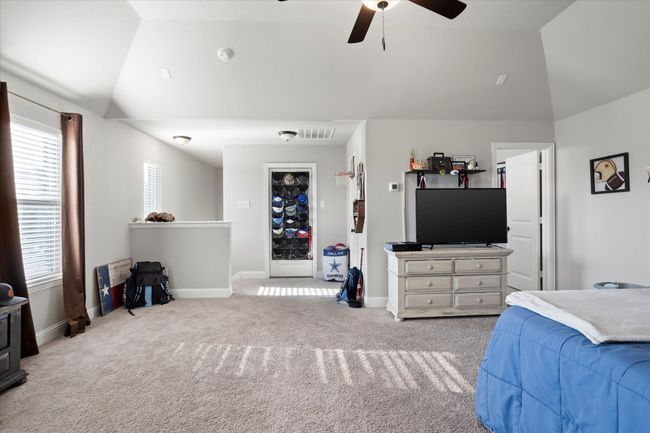 Bedroom featuring lofted ceiling, visible vents, light carpet, ceiling fan, and baseboards | Image 27
