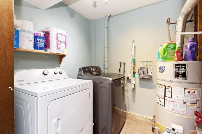 Washroom with water heater, washer and clothes dryer, and light wood finished floors | Image 19