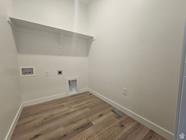 Laundry area with washer hookup, wood finished floors, baseboards, and electric dryer hookup | Image 12