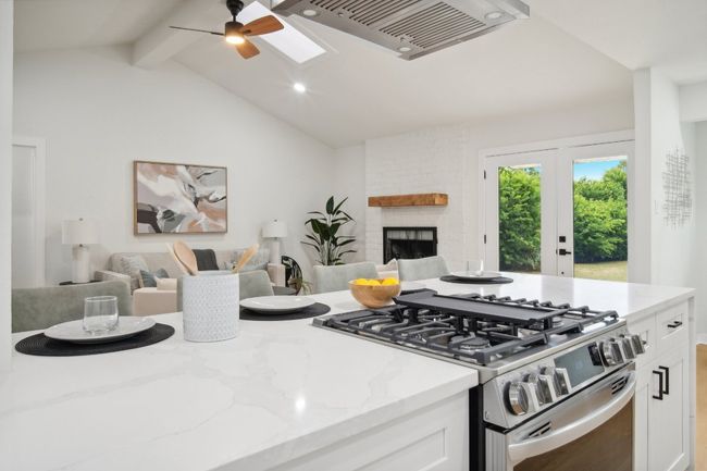Kitchen featuring open floor plan, white cabinets, and stainless steel range with gas cooktop | Image 9