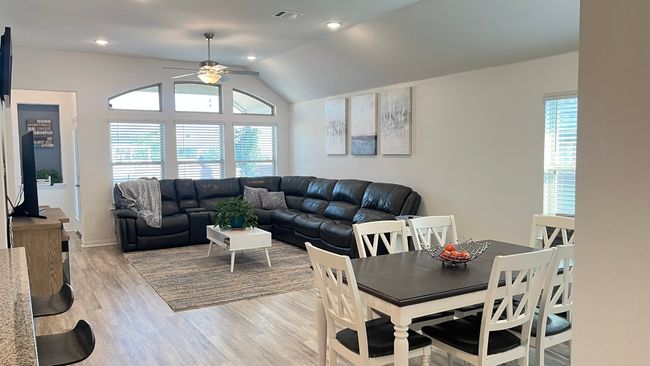 Living area with ceiling fan, light wood-type flooring, and lofted ceiling | Image 7