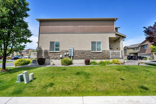 View of property exterior with stucco siding, stone siding, and a lawn | Image 28