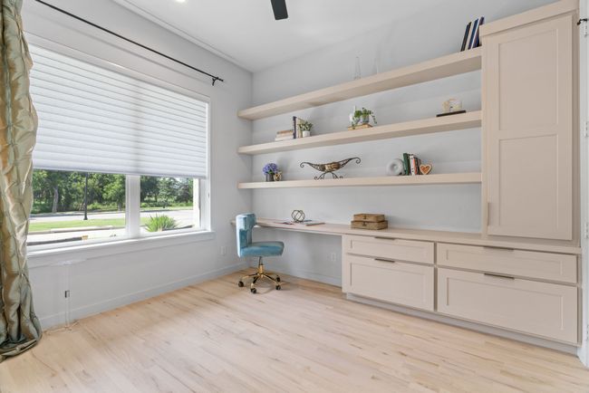 Unfurnished office featuring built in study area, light wood-style flooring, and ceiling fan | Image 22