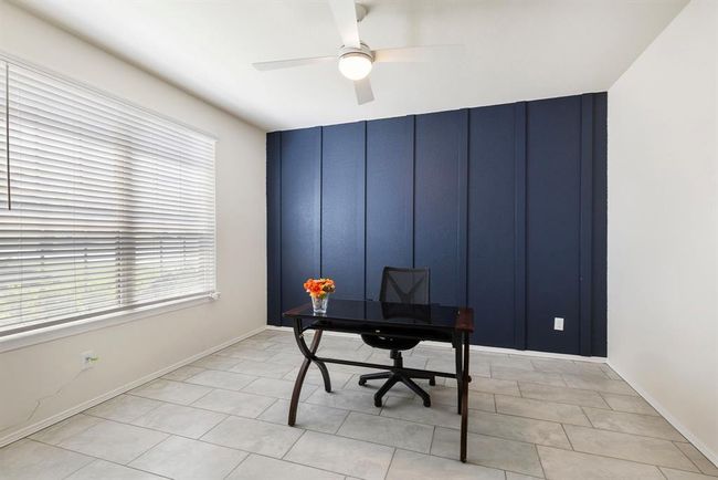 The home office features a handsome accent wall & French doors. | Image 8