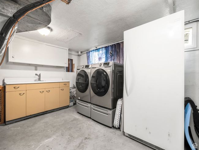 Washroom with separate washer and dryer, cabinet space, and a textured ceiling | Image 11