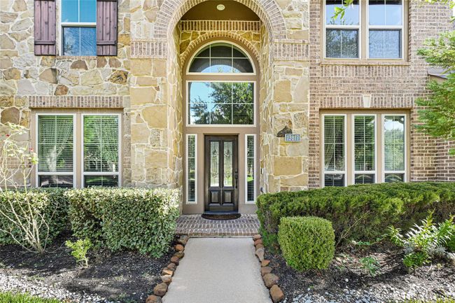 A soaring arched entryway welcomes you with grace—note the elegant sidelights and transom windows that pour sunlight into the grand foyer beyond. | Image 4