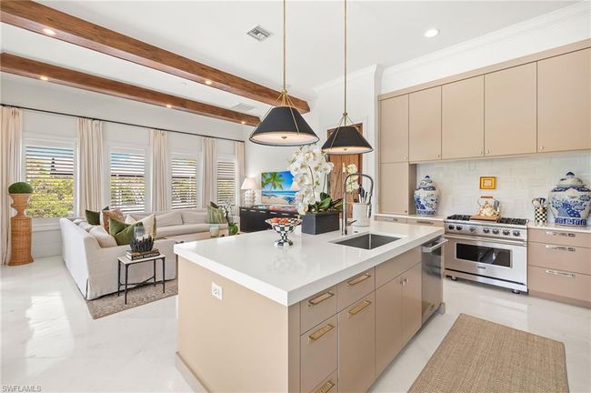 Kitchen featuring cream cabinets, appliances with stainless steel finishes, a sink, visible vents, and open floor plan | Image 12