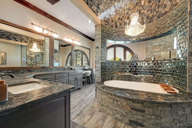 Full bathroom with a notable chandelier, a sink, double vanity, crown molding, and a garden tub | Image 25