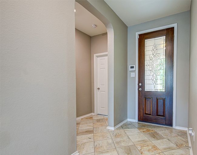 Foyer entrance with arched walkways and baseboards | Image 4