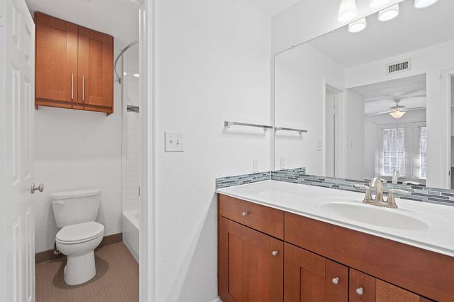 Bathroom with tile patterned floors, visible vents, toilet, ceiling fan, and vanity | Image 24