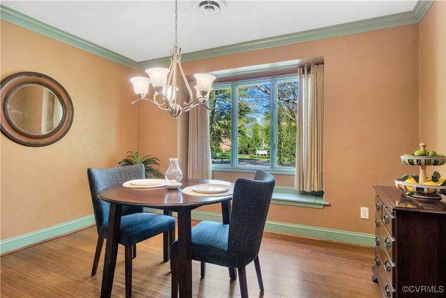 Dining room featuring baseboards, an inviting chandelier, and wood finished floors | Image 9