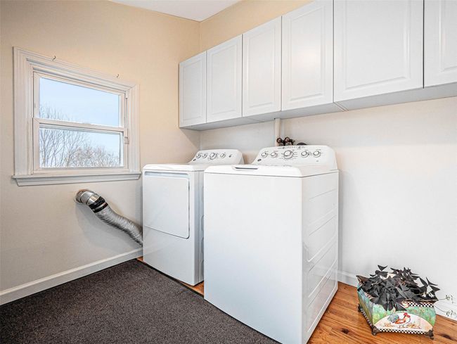Laundry room featuring washing machine and clothes dryer and cabinets | Image 21