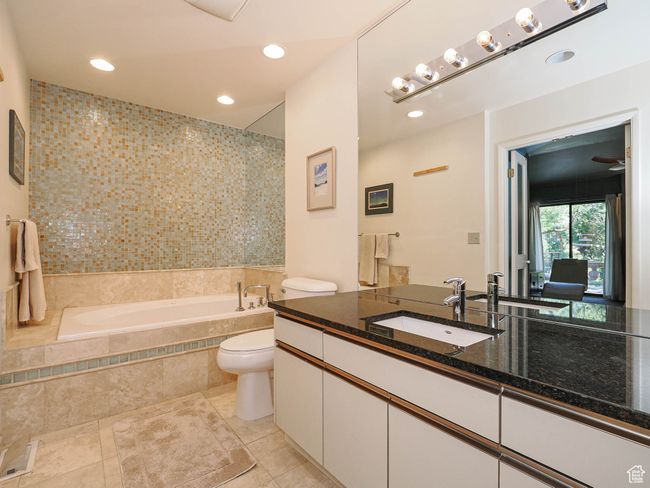 Full bath featuring tiled tub, vanity, tile patterned floors, and recessed lighting | Image 30