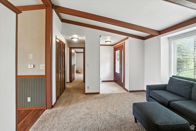 Living area featuring light carpet and beamed ceiling | Image 13