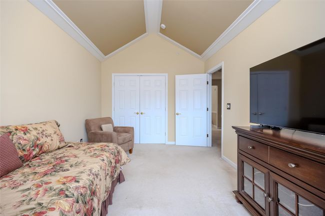 Bedroom with ornamental molding, vaulted ceiling, light colored carpet, and a closet | Image 19