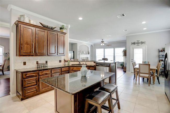 This photo showcases the home open concept kitchen, seamlessly connecting to the dining area, and offering a modern and inviting space for cooking and entertaining. | Image 14