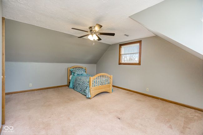 carpeted bedroom with baseboards, lofted ceiling, a textured ceiling, and a ceiling fan | Image 18