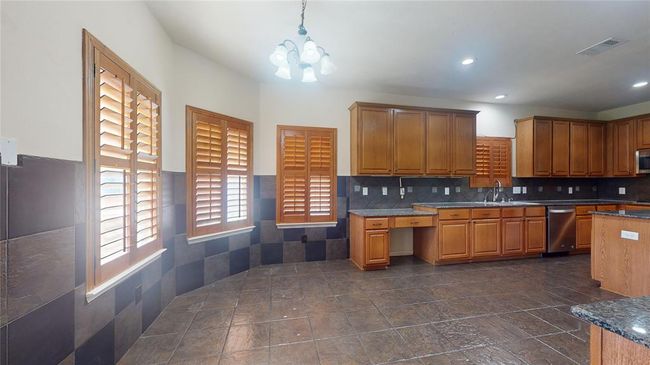 Spacious gourmet kitchen with elegant cabinetry, granite countertops, and abundant natural light. Perfect for culinary enthusiasts. | Image 12