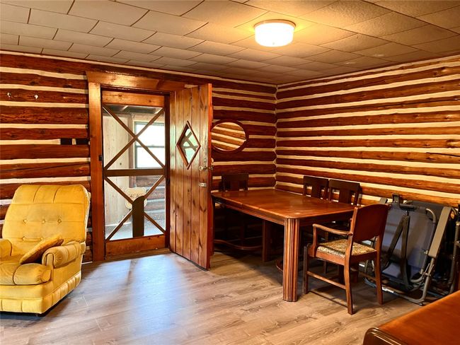 Dining space with wood finished floors and wooden walls | Image 10