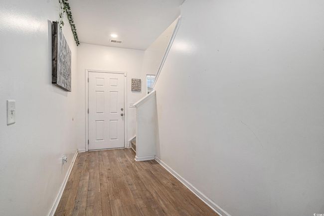 Doorway to outside featuring baseboards, wood finished floors, and stairway | Image 21