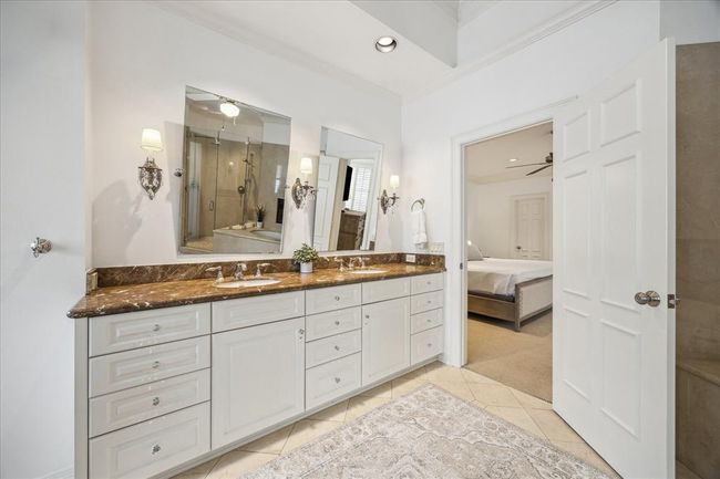 Primary bathroom with dual vanities. Emperador marble counters. | Image 20