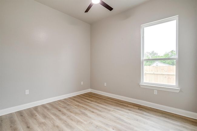Empty room with light wood-type flooring, baseboards, and ceiling fan | Image 27
