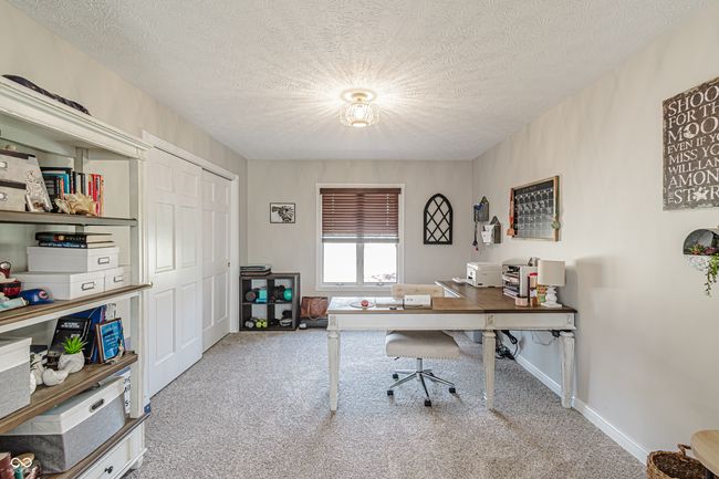 office area or can be used as a 3rd bedroom on main level featuring baseboards, carpet floors, and a textured ceiling | Image 14