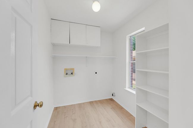 Laundry area featuring baseboards, light wood-style floors, hookup for a washing machine, cabinet space, and electric dryer hookup | Image 11