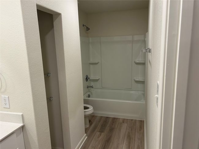 Bathroom with shower / washtub combination, toilet, vanity, and wood finished floors | Image 13