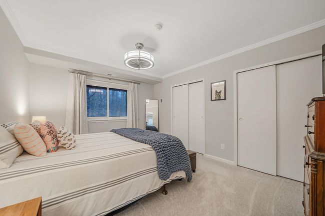 Bedroom with two closets, ornamental molding, baseboards, and light colored carpet | Image 19