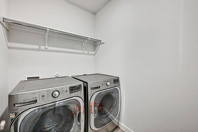 The functional laundry room provides convenient space for chores, equipped with ample storage for all your laundry needs. | Image 23
