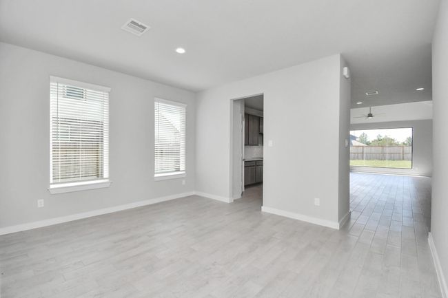 Make memories gathered around the table with your family and friends! This spacious dining room features elegant flooring, custom paint, and adjacent to family room and kitchen for open concept feel. | Image 9