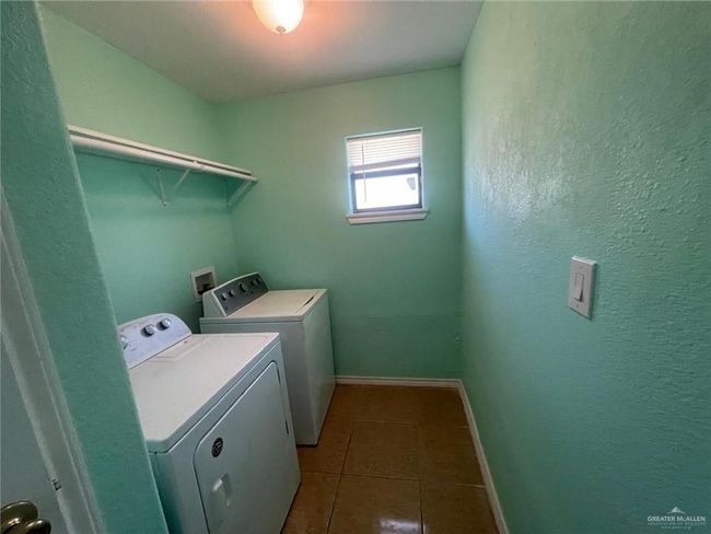 Laundry room featuring laundry area, dark tile patterned flooring, separate washer and dryer, and baseboards | Image 9