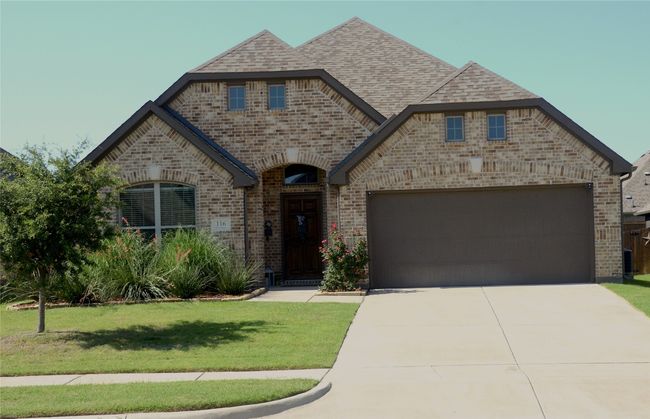 French country style house with brick siding, an attached garage, driveway, a front lawn, and a shingled roof | Image 30