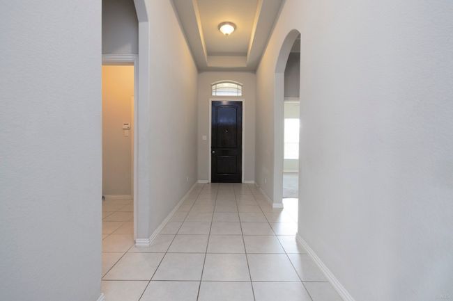 Hallway featuring light tile patterned floors and arched walkways | Image 5