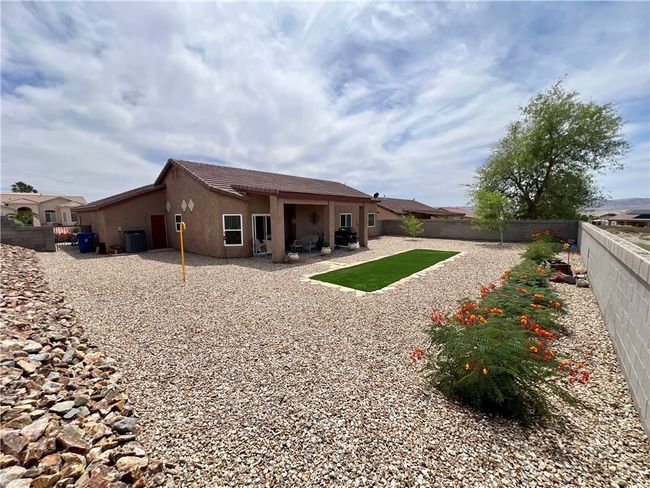Back of property with stucco siding, cooling unit, a fenced backyard, and a patio | Image 41
