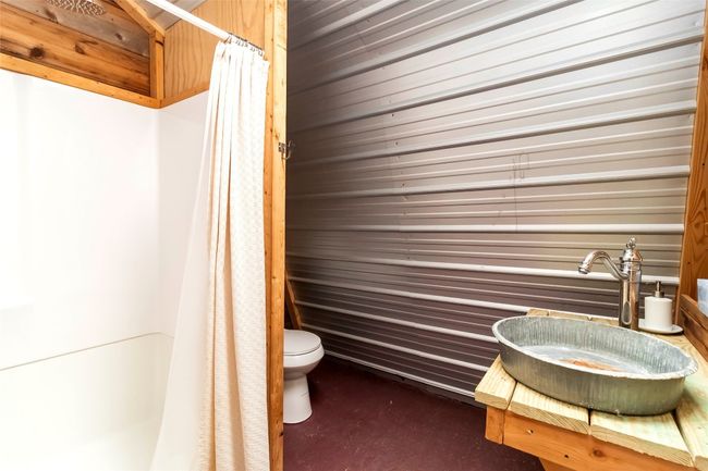 Another full bathroom in the bunkhouse with a shower with shower curtain and vanity | Image 30