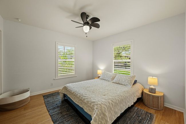 The primary bedroom features windows on two walls for natural light. | Image 13