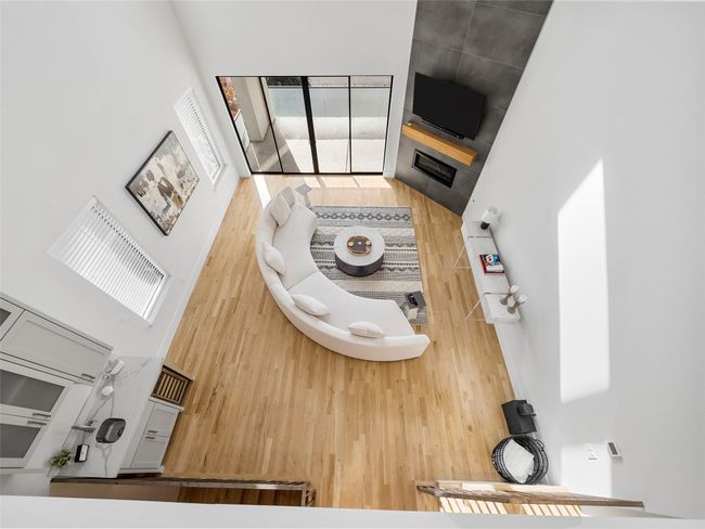 Living room with a towering ceiling and wood finished floors | Image 21
