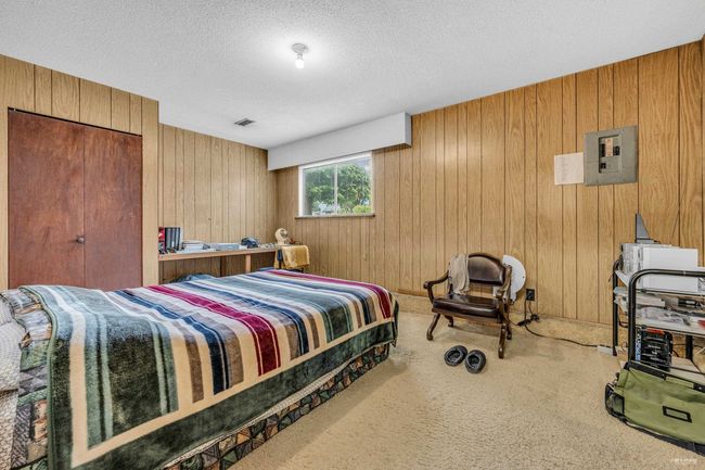 Bedroom featuring electric panel, wooden walls, carpet floors, and a textured ceiling | Image 7