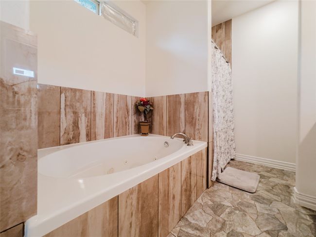Bathroom with a tub with jets and curtained shower | Image 20